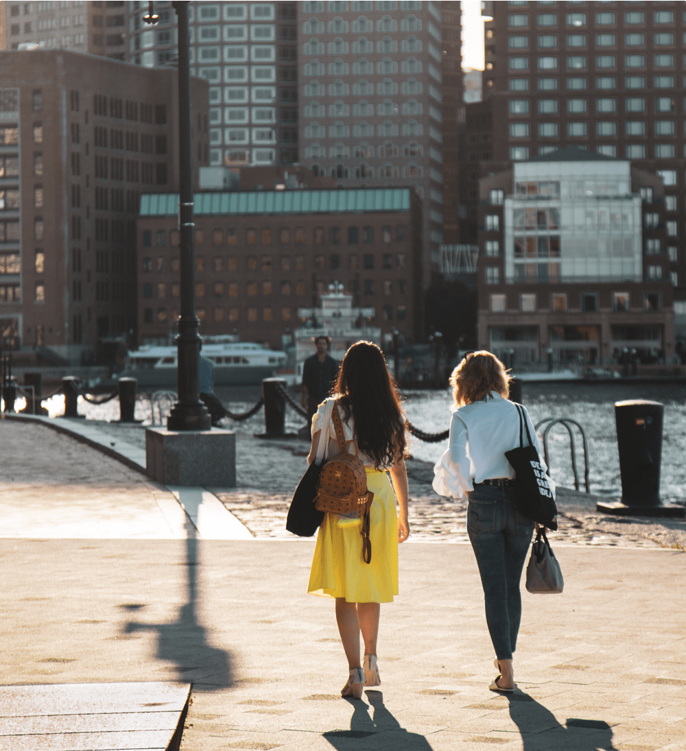 Two young women walk together in Boston Seaport